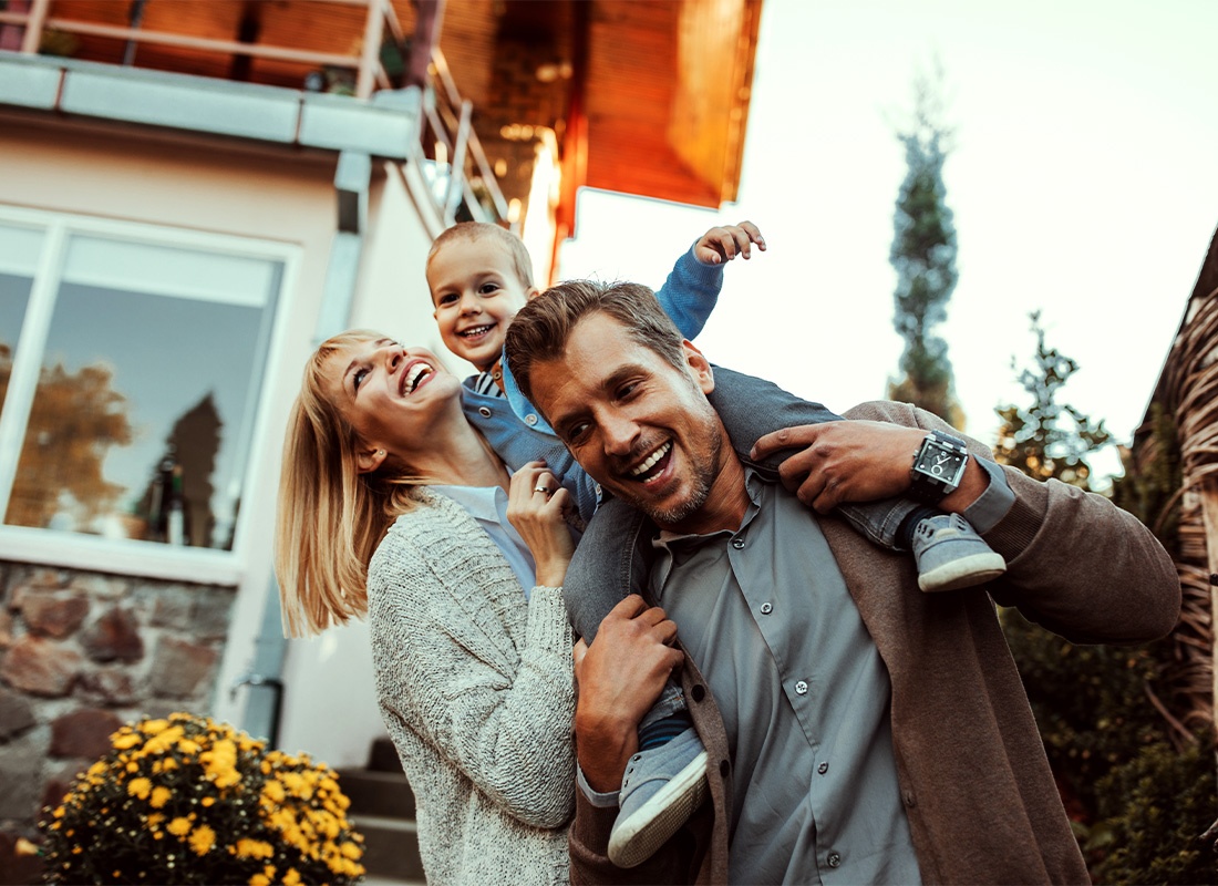 Personal Insurance - Mother and Father Holding Their Small Child While Outside