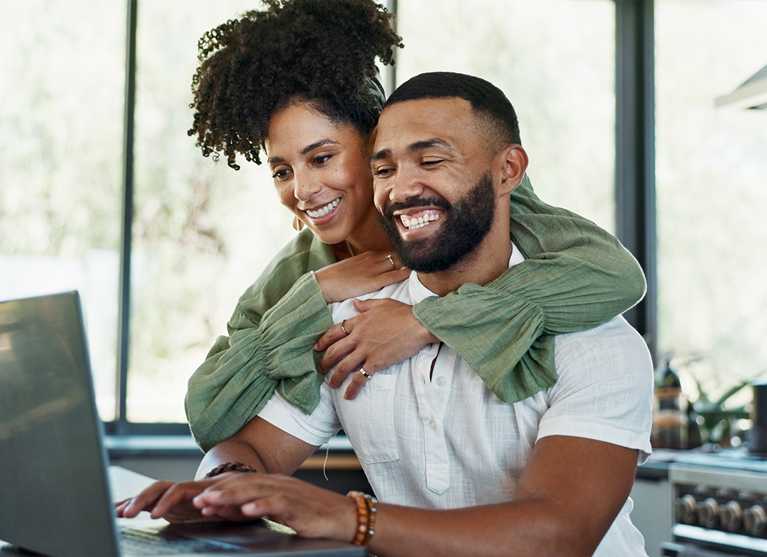 Read our Reviews - Couple With Laptop at Home in the Kitchen Investing Money